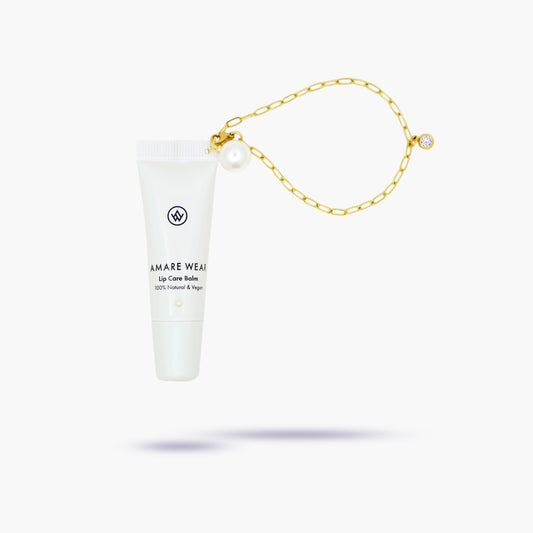 White lip balm tube with gold chain on a white background